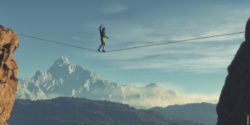Man balancing on rope between mointains; copyright: Fotolia