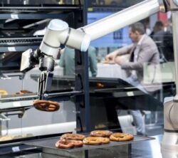 A robot arm moving one of many pretzels; copyright: Andreas Wiese/Messe Düsseldorf